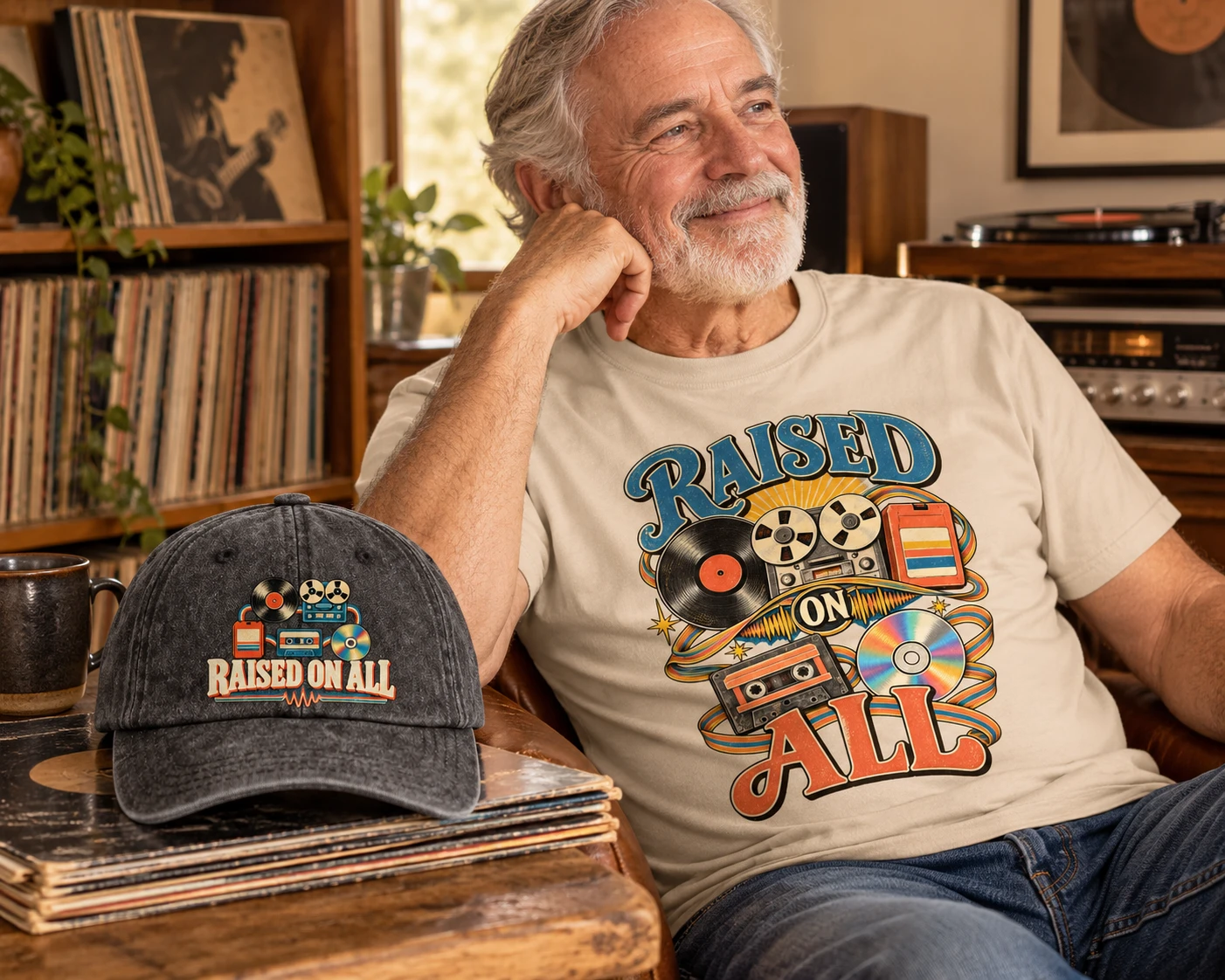 Man wearing a sand Raised On All T-shirt beside a black printed cap and records